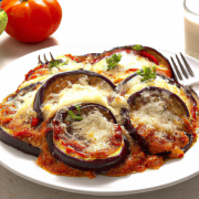 Eggplant Parmesan (Vegetarian) 5 medium eggplants, sliced into 1/2-inch-thick rounds 2 cups all-purpose flour 4 large eggs, beaten 3 cups breadcrumbs 2 cups marinara sauce 2 cups grated mozzarella cheese 1 cup grated Parmesan cheese Preheat oven to 375°F. Dredge the eggplant slices in flour, dip in beaten eggs, and coat with breadcrumbs. Place the breaded eggplant slices on a baking sheet and bake for 20-25 minutes, until golden brown. In a large baking dish, layer the eggplant slices, marinara sauce, mozzarella cheese, and Parmesan cheese. Repeat layers until all the ingredients are used up, finishing with a layer of cheese on top. Bake for 25-30 minutes, until the cheese is melted and bubbly.