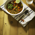 Lentejas y verduras al curry (vegano),caliente ligero, servido en mesa de madera, cubiertos,