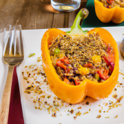 Quinoa Stuffed Bell Peppers (Vegan), warm light, served on wooden table, cutlery,