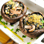 Stuffed Portobello Mushrooms with Spinach and Quinoa (Vegan) 10 large portobello mushrooms, stems and gills removed 2 tbsp olive oil 2 cups chopped onion 2 cups cooked quinoa 2 cups chopped fresh spinach 1/2 cup nutritional yeast Salt and pepper, to taste Preheat oven to 375°F. Place the portobello mushrooms on a baking sheet, cap side down. Heat olive oil in a large skillet over medium heat. Add onion and cook until softened. Stir in quinoa, spinach, and nutritional yeast. Season with salt and pepper. Spoon the mixture into the mushroom caps. Bake for 20-25 minutes, until the mushrooms are tender and the filling is heated through.